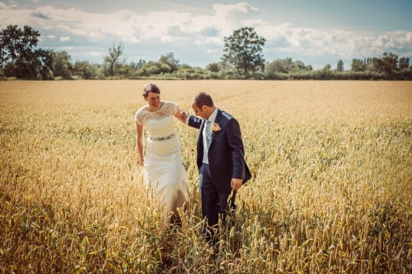 Gloucestershire bride and groom walking through cornfield